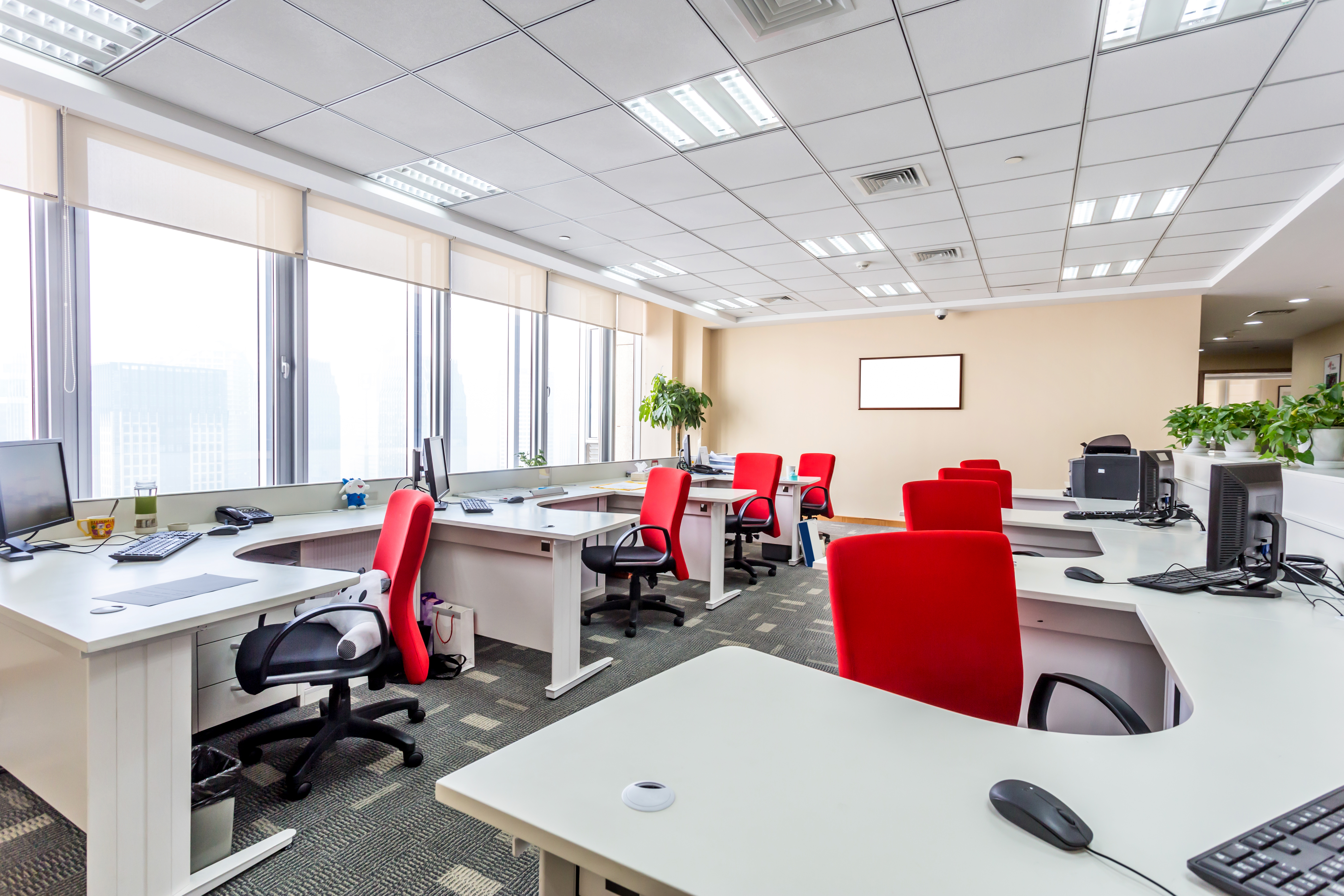 View of modern office with white desks and red chairs