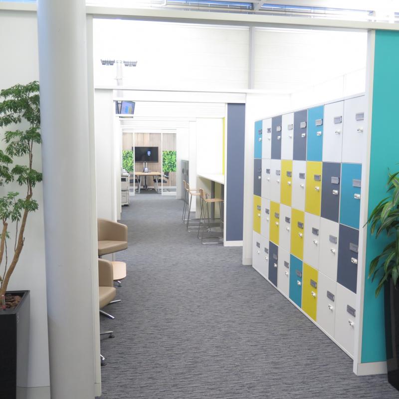 View through partitioned area with coloured lockers and soft seating.