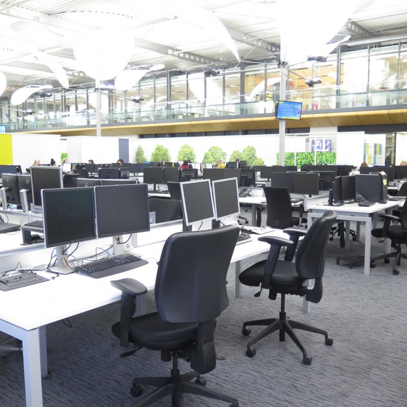 View from open plan desk area looking across the desks to the first floor restaurant