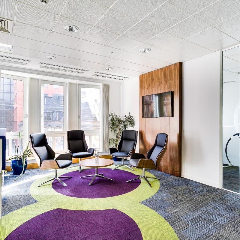 view of reception seating area with 4 individual swivel chairs in front of large window