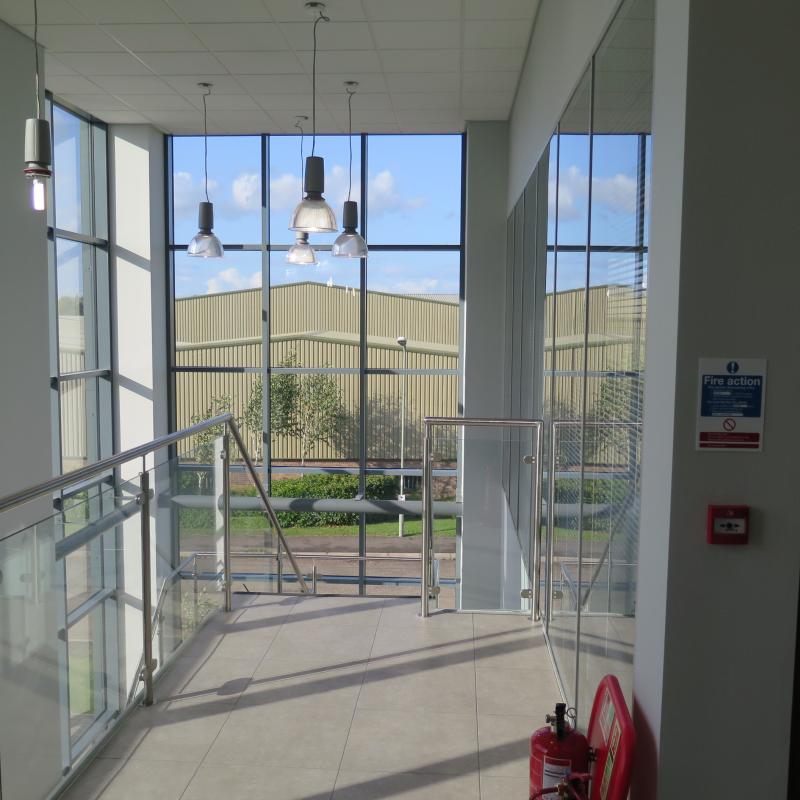 view of glazed balustarde to staircase looking through glazed corner of building to outside