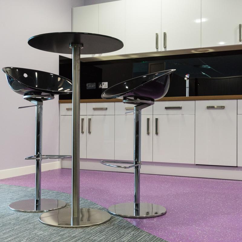 view of staff room with white kitchen units and high stools