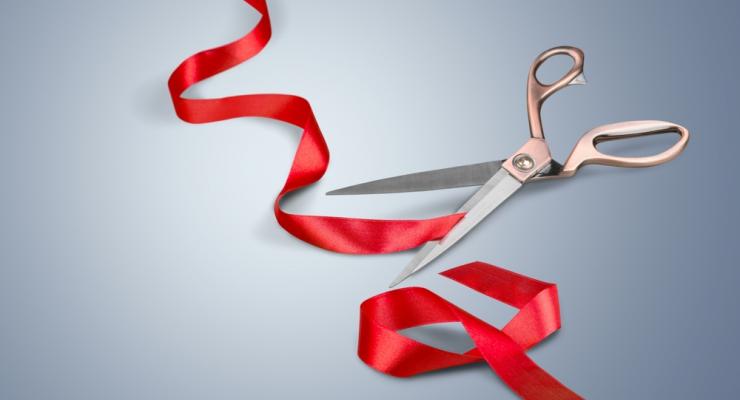 view of red ribbon having been cut by shiny scissors